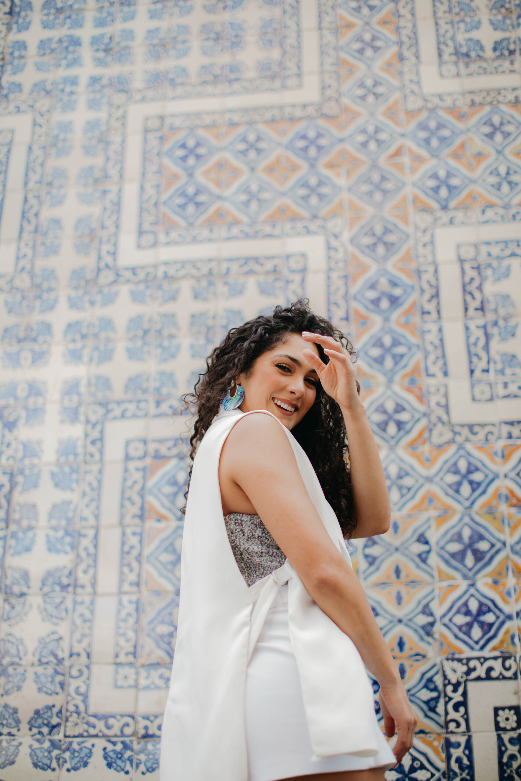 Erika Smiling over her shoulder near a blue tiled wall - EP. 92: Break up With Your Checklist Relationship with Karina F. Daves
